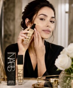 Woman putting on Nars natural radiant longwear foundation