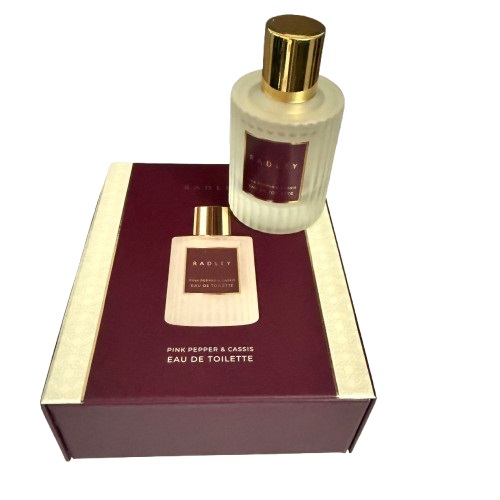 A bottle of Radley perfume called pink cassis standing on top its box