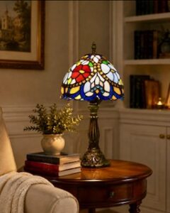 A Tiffany lamp with red rose on a table in a room