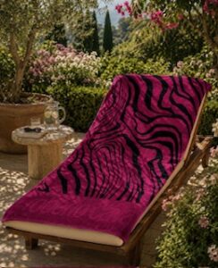 A Roberto Cavalli zebra print beach towel on a chair in the garden
